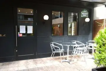 <p>ด้านหน้าร้าน&nbsp;Le Petit Mac - Oike (ル・プチメック 御池) ที่มีมุมนั่งชิลล์สบายๆ กับร้านเท่ๆ ในโทนสีดำ</p>