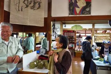 <p>The little market, Kurashi no Yakata, and its owner (on the left)</p>
