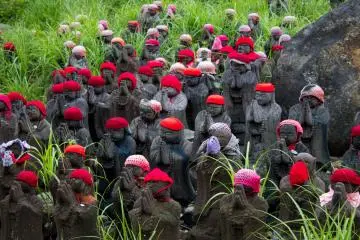 <p>Hundreds of Jizu statues stand as guardians for the souls of children, a part of Buddhist tradition.</p>