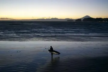 <p>A surfer coming out of the water with Mt. Fuji in the background</p>
