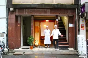 <p>Master Chef Hisayoshi Iwa and Chef Shigeyuki Tsunodo standing front and center of Sushi Iwa in Ginza, Tokyo.</p>