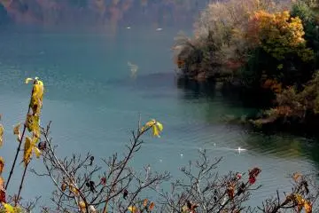 <p>The water reflects the hills, and turns from blue to green and purple in the shadows</p>