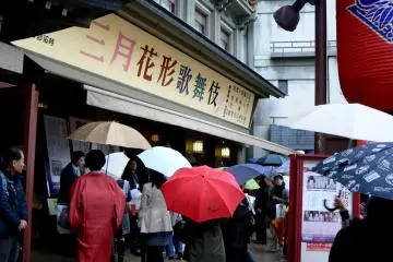 <p>Theater goers under their umbrellas</p>