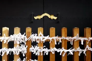 <p>Fortune papers tied to a railing fence</p>