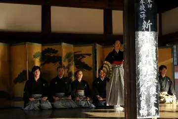 A beautiful gold screen with a painting of a pine tree formed a backdrop to the stage &nbsp;