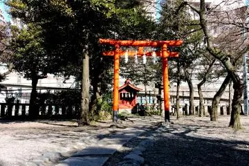 <p>A tiny shrine with one red tori stands in a corner</p>