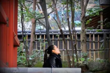 <p>A girl in thought sitting on the outside veranda of Kannon Hall looking into the space</p>
