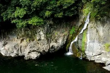 <p>A small waterfall flows down the side of the gorge</p>