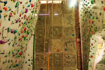 <p>The wall pictured in front has built in features that make you feel as if you are on real rock. These routes can be top roped or lead. Climbers have the option to use an auto belay on either wall.&nbsp;</p>