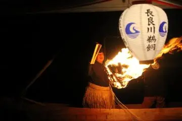 A fishing master putting pine wood in the bonfire