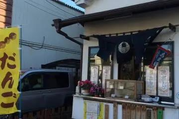 This is Ikeda Shop's main store, selling dango (small pounded rice balls on a stick, covered with various sauces) that catches customers attention as they walk by the traditional Japanese-style building.