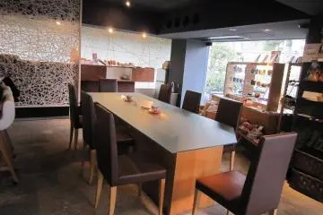 가게안. 중앙에 큰 테이블, 벽쪽과 창가에 카운터석이 연결되어 있다