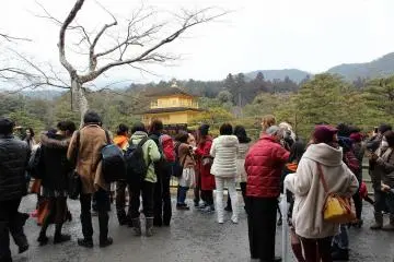 많은 관광객이 금각에 넋을 잃고 바라보다
