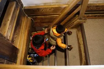 Small children assist one another as they make their way up the challenging staircase