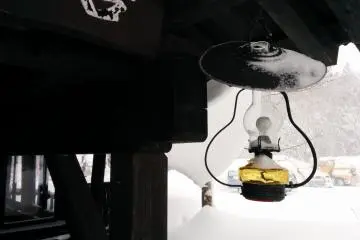<p>A snowy lantern hangs near the cafe next to the parking lot</p>