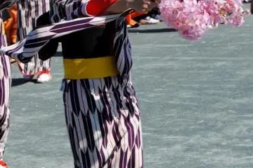 One of the princess` attendants performs in a traditional dance with a spray of blossoms
