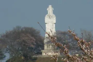 The Kannon overlooking the tree-lined river