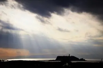 In the late afternoon the sky was covered with deep clouds and the sun was setting. Then I saw sunshine cascading through the gap of clouds. It appeared as though a god was descending surrounded by light!
