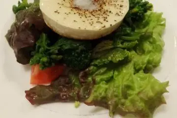 <p>Warm camembert cheese tops a salad of fresh greens</p>