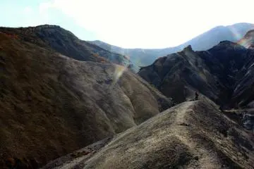 <p>Jalur pendakian membawa Anda menuju ujung yang mengerikan, lanskap yang sepi - pengingat bahwa Anda berjalan melalui daerah yang aktif secara geotermal.</p>