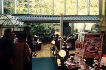 Meja restoran berada di luar di taman di mana hotel ini memiliki air terjun sendiri.