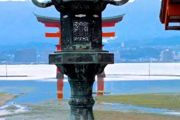 <p>A shrine lantern and torii gate at low tide</p>