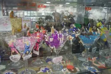 <p>กาชาปองชุดสาวน้อยเกาะแก้ว (Cup no Fuchiko) ที่ร้านติดบันไดเลื่อน</p>