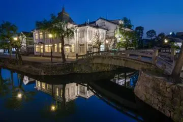 <p>As the blue hour colors deepen, so does the atmosphere of the quarter. This ancient stone bridge is a great place to enjoy the mixture of lights, colors, and reflections.</p>