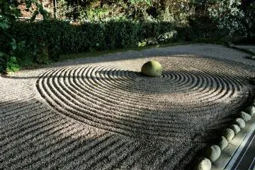 <p>A dry garden of raked sand surrounds a stone as round as a pearl</p>