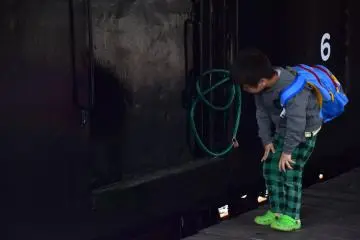 <p>Intrigued, a boy was trying to look inside Teki 6, but sadly the door was closed and locked securely.</p>