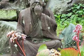 <p>Why is this statue picking his nose and the one behind him drinking heavily? A third (just out of the frame) is eating mitarashi dango, a traditional Japanese dessert. Hmmm.</p>