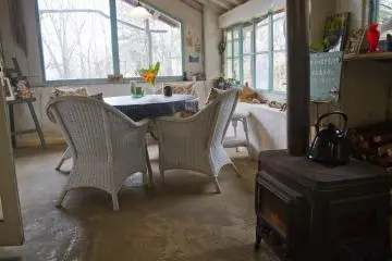 Ruang yang bermandikan cahaya matahari dihangatkan dengan menyalakan kompor kayu bakar di musim dingin dan pemandangan yang mengarah ke kebun-kebun