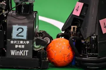 <p>Mid-size robots of Kanazawa Institute of Technology (left: WinKit) and Tokyo Polytechnic University (right: RV-Infinity) wrestling over a ball</p>