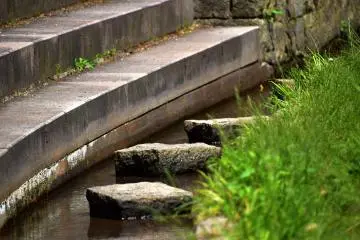 Langkah-langkah batu di sungai kecil di sepanjang jalan