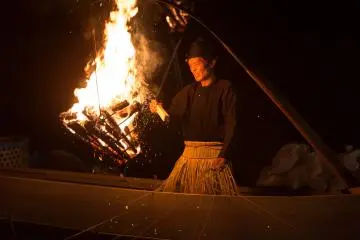 <p>Stoking the fire to bring the fish to the surface</p>