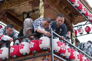 <p>Crew members work to attach lanterns to the floats</p>