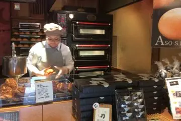 <p>At Patisserie Roku, the choux pastry straight out of the oven is being filled with custard cream.</p>
