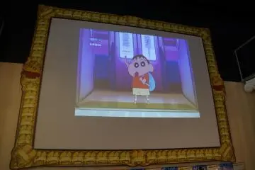 <p>A large screen playing Crayon Shin-chan episodes and promoting the most recent movie greets visitors at the entrance. A very appropriate design frames the screen.&nbsp;</p>