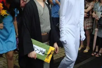 It can be difficult to cosplay a cat, but this person seems to be managing.  Natsume Takeshi and Nyanko-sensei from Natsume Yuujinchou
