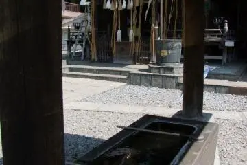Air untuk pemurnian. Celupkan gayung bambu dan cucilah tangan Anda.