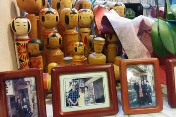 <p>Kokeshi dolls with photos of family and friends of the ryokan&nbsp;add a bit of charm</p>