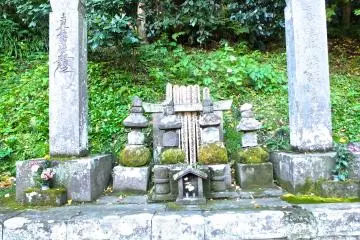<p>A collection of very old temple stones flanking a golden lotus;&nbsp;Myohonji Temple, Kamakura</p>
