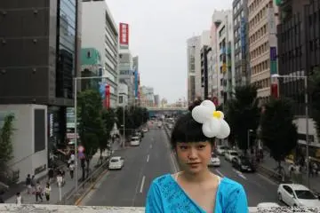 A flower girl adding color to a somewhat grittier street of Tokyo