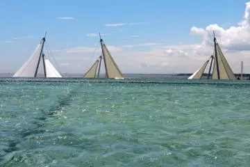 <p>Shallow infinity pools around the aquarium lead the eye toward the ocean</p>