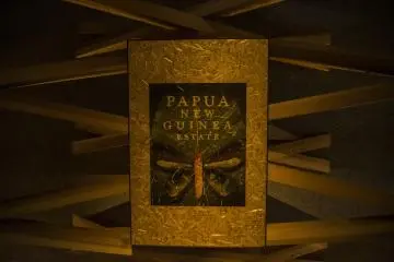 Karya seni digantung langsung di atas tongkat kayu, tampak tergantung di udara.