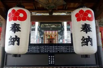 <p>Two lanterns hang over the temple's offering box</p>