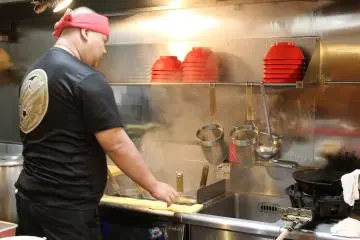 <p>The chef busy cooking noodles</p>