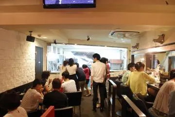 <p>The visitors look into the glass enclosure where the four penguins live.&nbsp;</p>