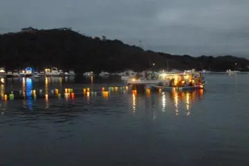 A boat floats lanterns on the lake