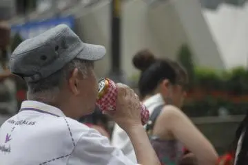 A spectator has a drink while enjoying the show.&nbsp;